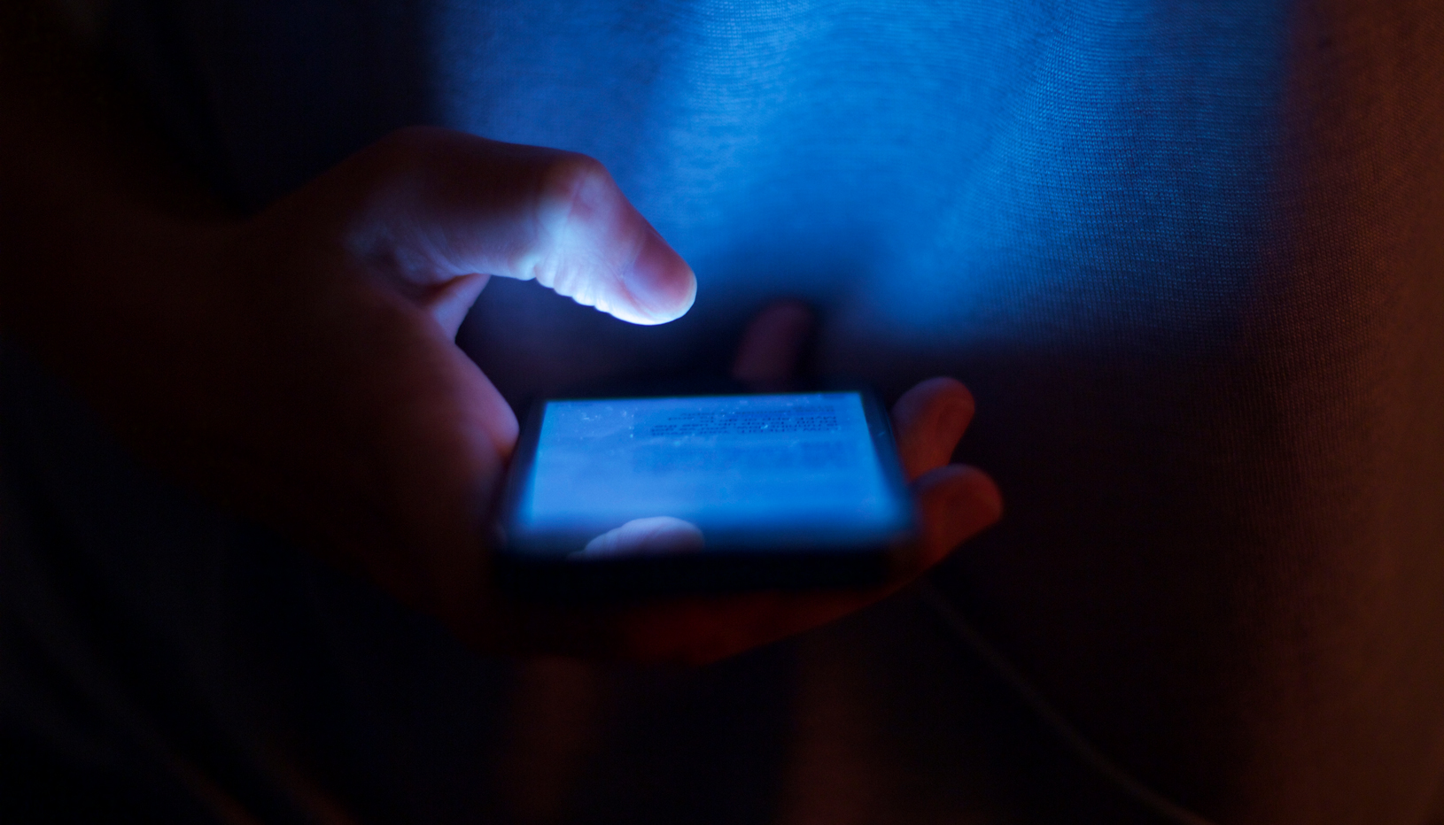 Person holding cell phone in the dark