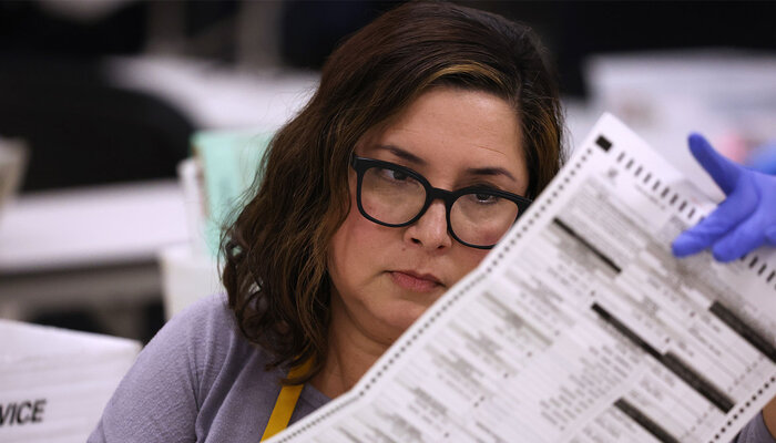 Election worker looking over a ballot.