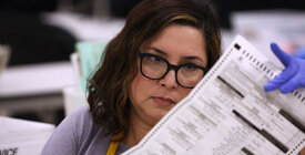 Election worker looking over a ballot.