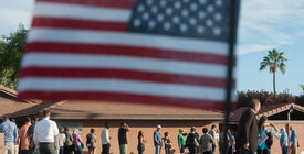 Voters in line with American flag in foreground