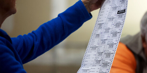 Election officials checks a voter's ballot.