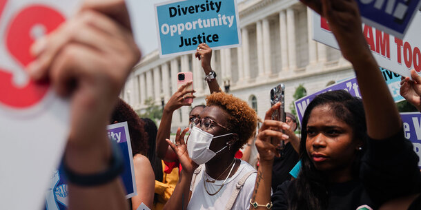 Protesters with pro-diversity and inclusion signs