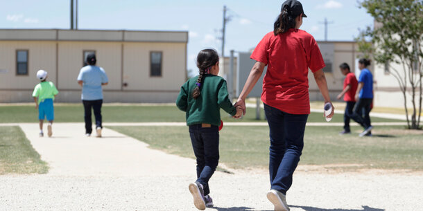 Mother and child walking in family detention center